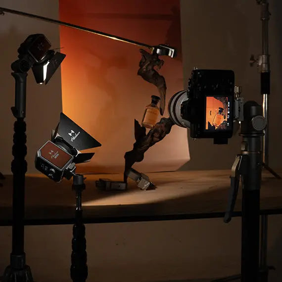 Hobolite Micro portable LED lights on photography stands with warm orange backdrop and camera display.