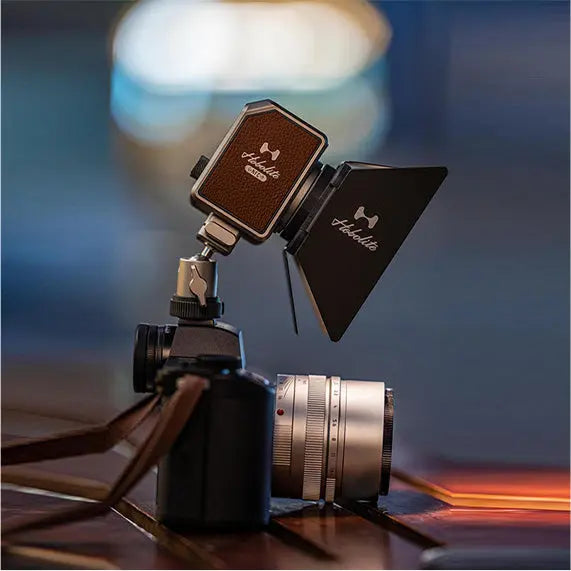 Hobolite Micro 8W LED light attached to camera, with brown leather panel and black barn door accessory.