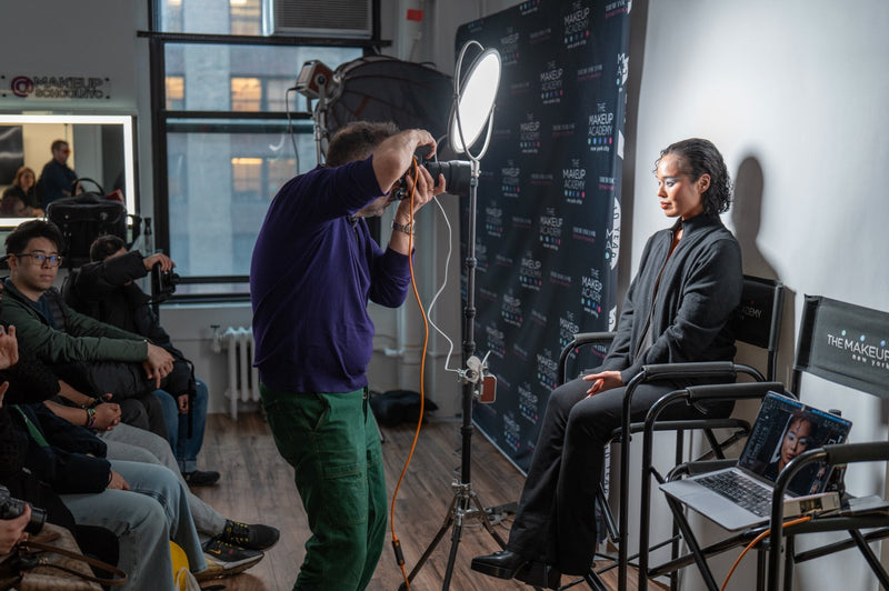 A photographer makes a portrait under a Harlowe Sol round panel light at a Harlowe Creators × Makeup School NYC event in New York City.