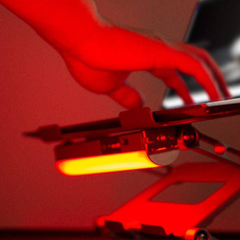Harlowe Blade 5 tube light with yellow glow, adjusted in dramatic red lighting environment.