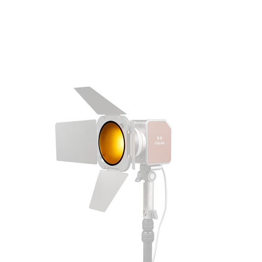 Hobolite Avant professional lighting fixture with amber color gel and barn doors on a stand.