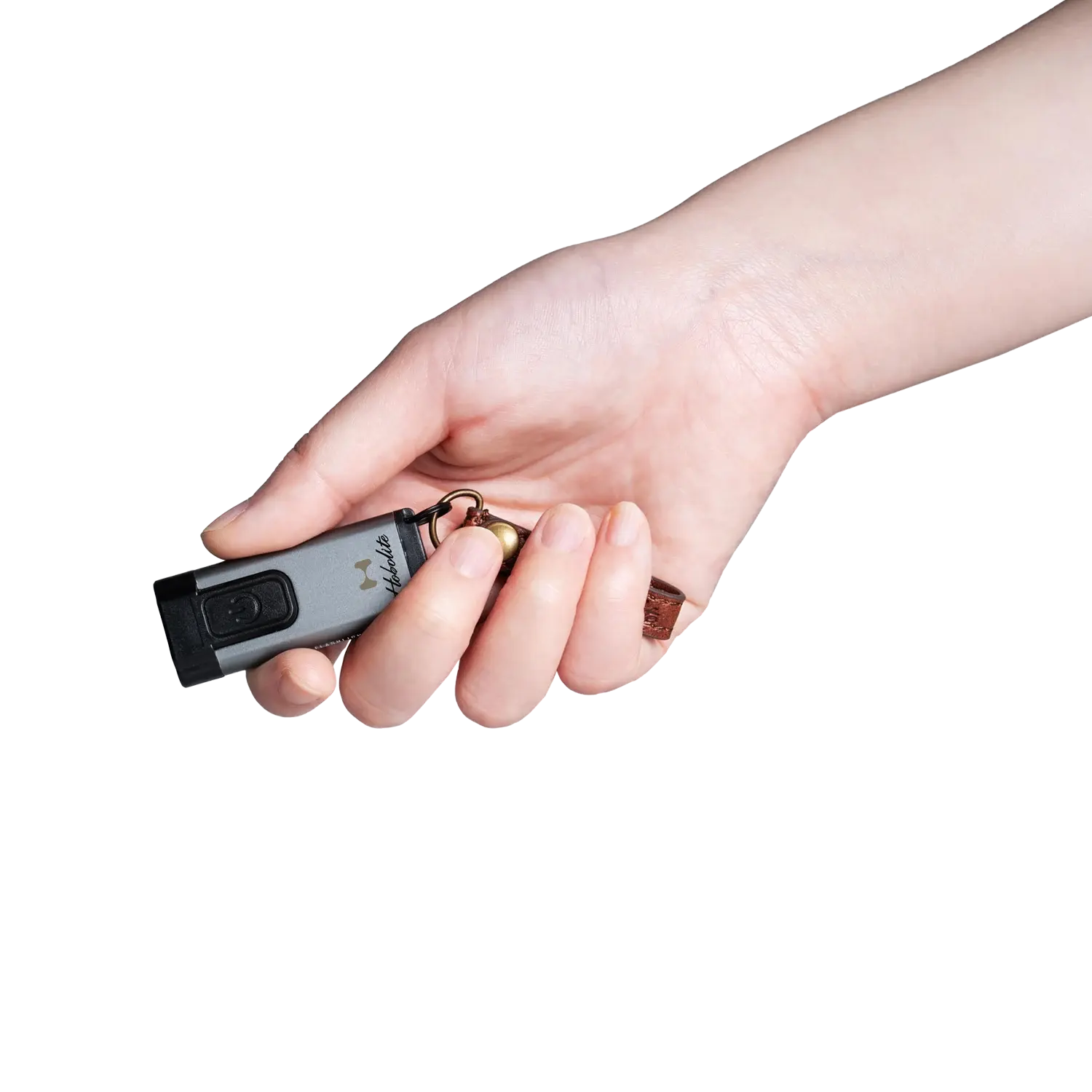 Hobolite compact keychain light, silver, held in hand with brown leather fob and brass ring.