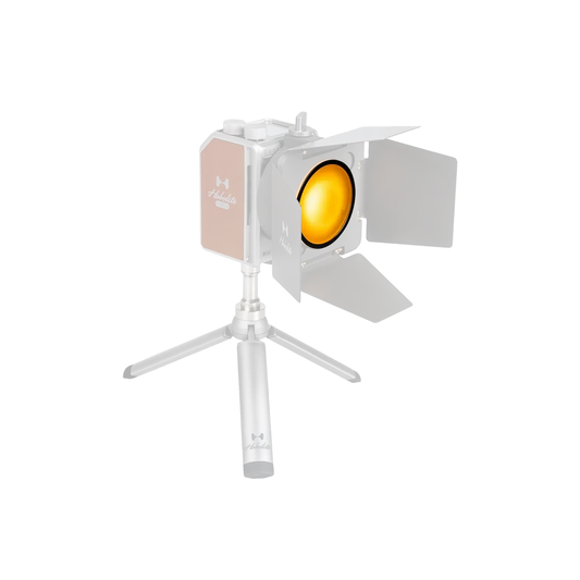 Hobolite Mini LED light with yellow gel filter and barn doors on tripod.