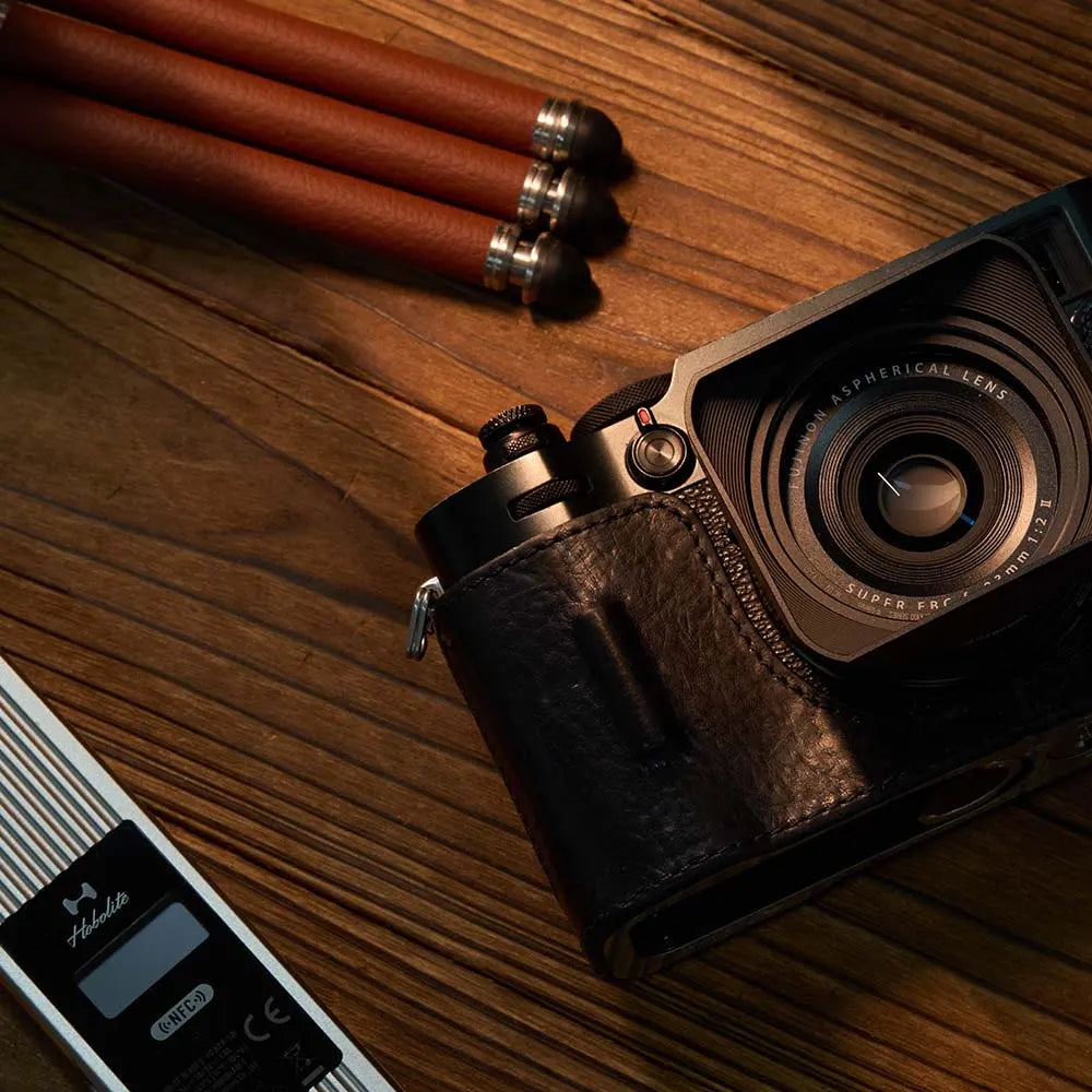Harlowe Blade 5 Reddish Tube Lights with leather-wrapped camera and digital display on wooden surface.