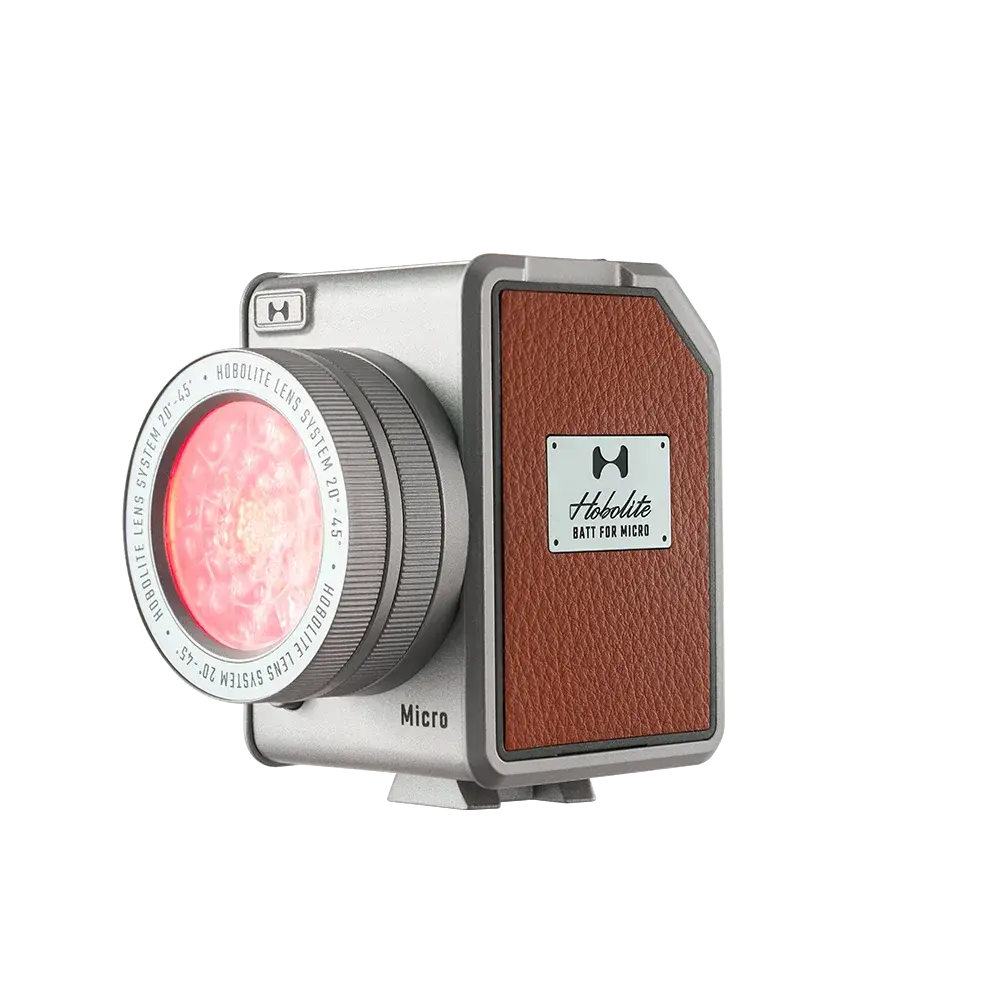 Harlowe Micro LED light, silver with brown leatherette, adjustable lens emitting pink light, product appearance.