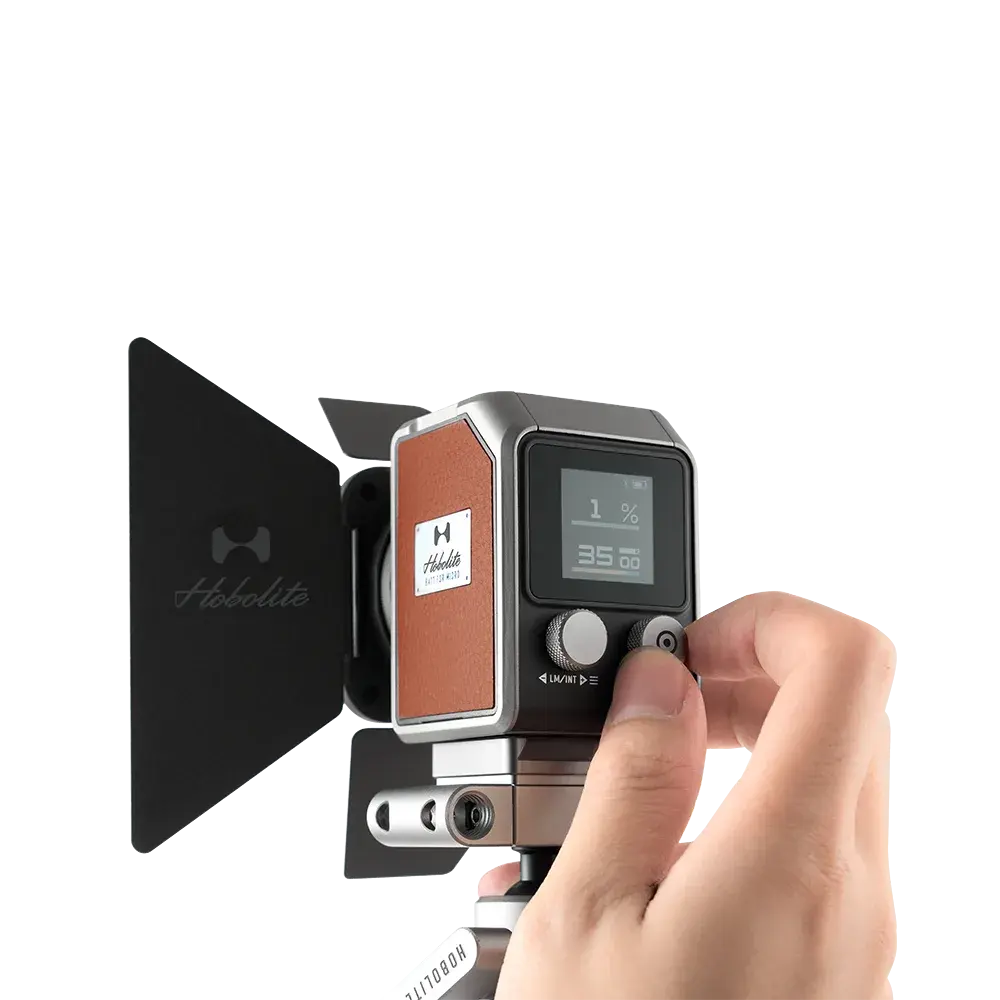 Compact Harlowe Micro LED light with barn doors, digital display showing 1% brightness, highlighting portable professional design.