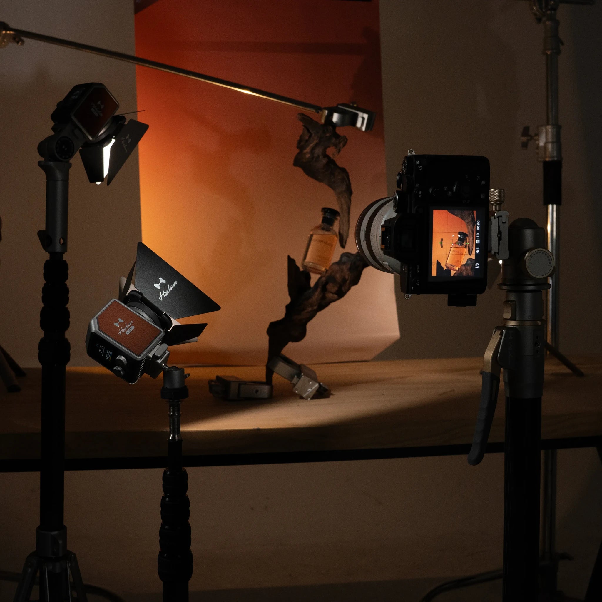 Hobolite Micro portable LED lights on photography stands with warm orange backdrop and camera display.