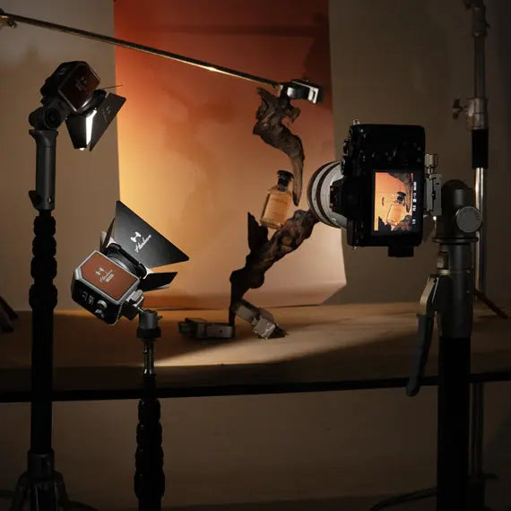 Harlowe Micro LED lights used in a professional product photoshoot setup with camera and orange background.