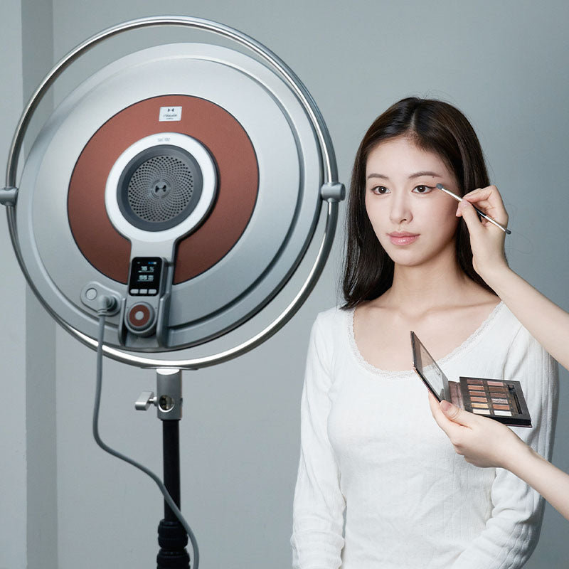 Harlowe Sol 100W LED panel light used for makeup application, showing soft illumination on a woman's face.