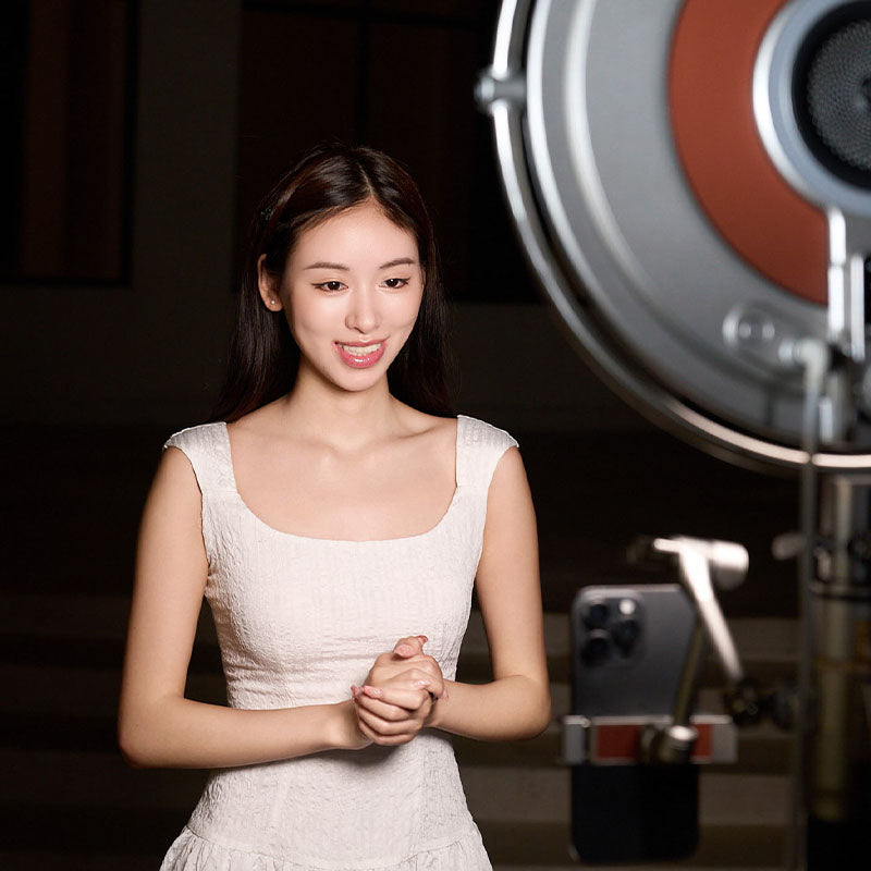 100W round LED panel light softly illuminating content creator in white dress, demonstrating professional video lighting.