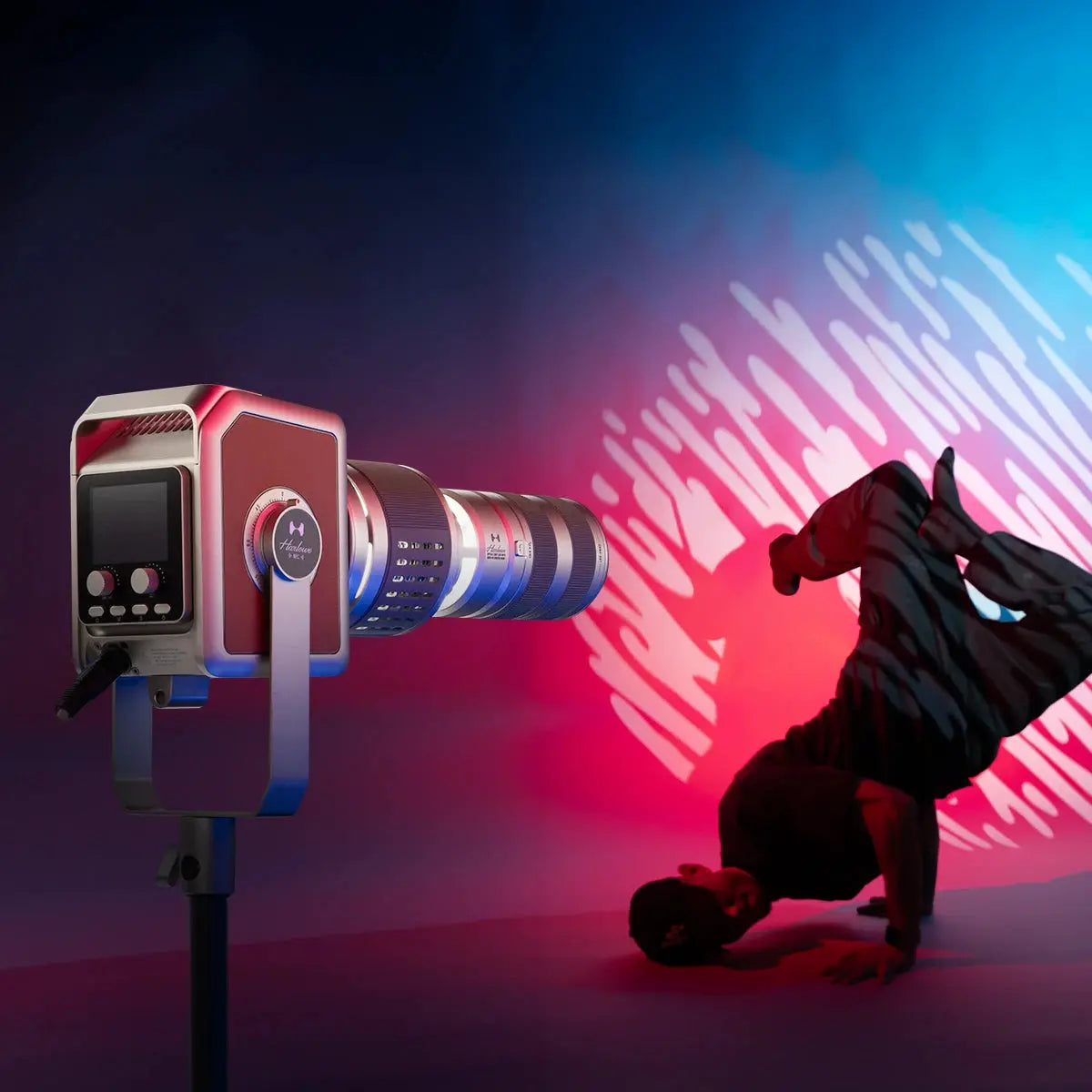 Harlowe Pro optical projector with gobo lens, casting abstract light on breakdancer against red and blue backdrop.