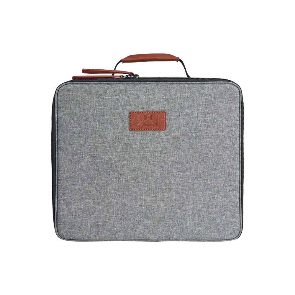 Grey fabric carrying case for Harlowe Sol LED light, featuring brown leather handle and logo patch.