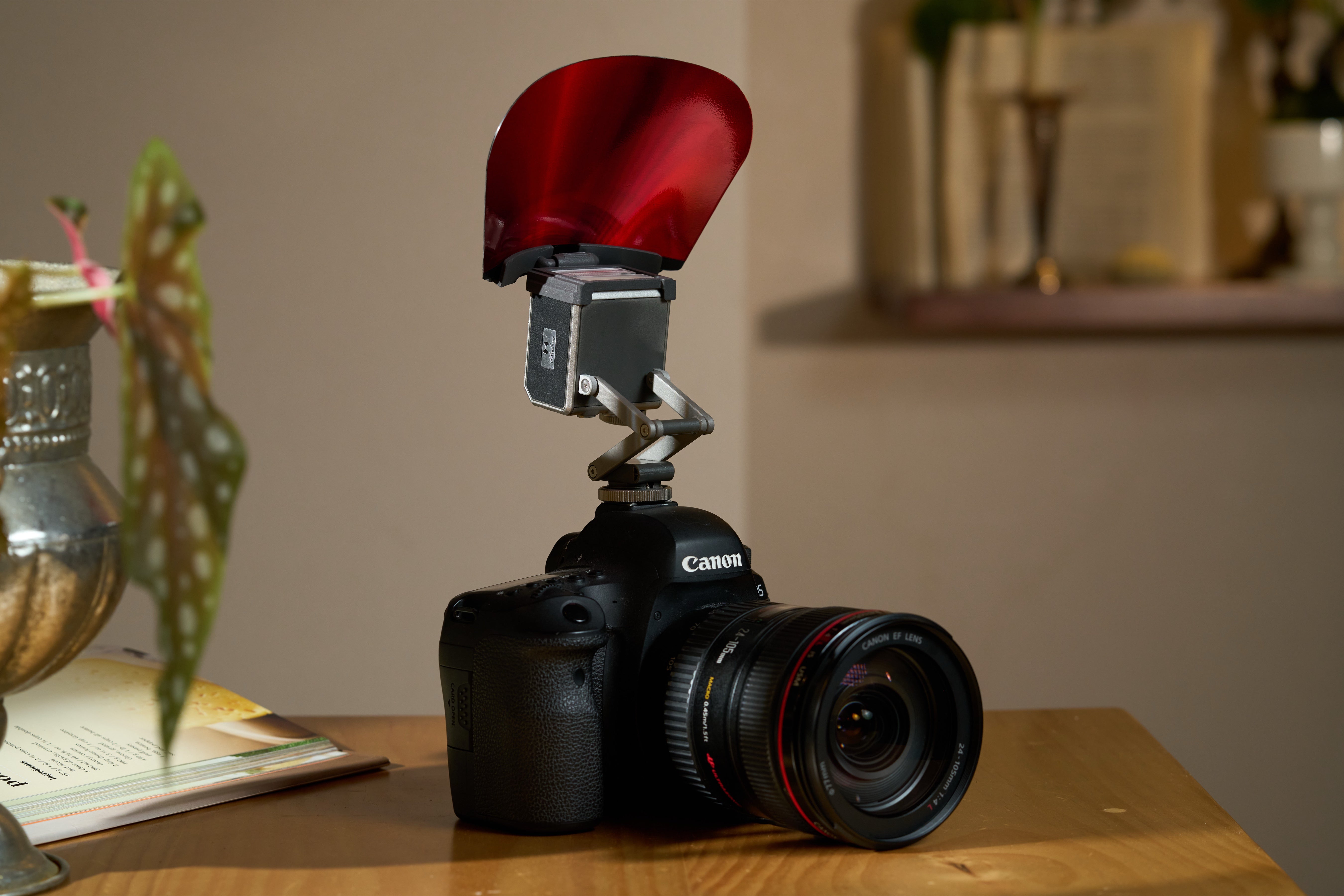 Pocket Flash with red bounce diffuser mounted on a camera indoors